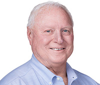 Chris smiling in front of a white background