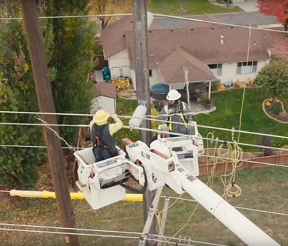 Linemen in bucket truck working on transmission line