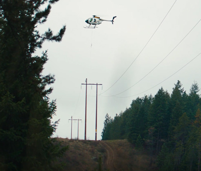 Helicopter flying over transmission line